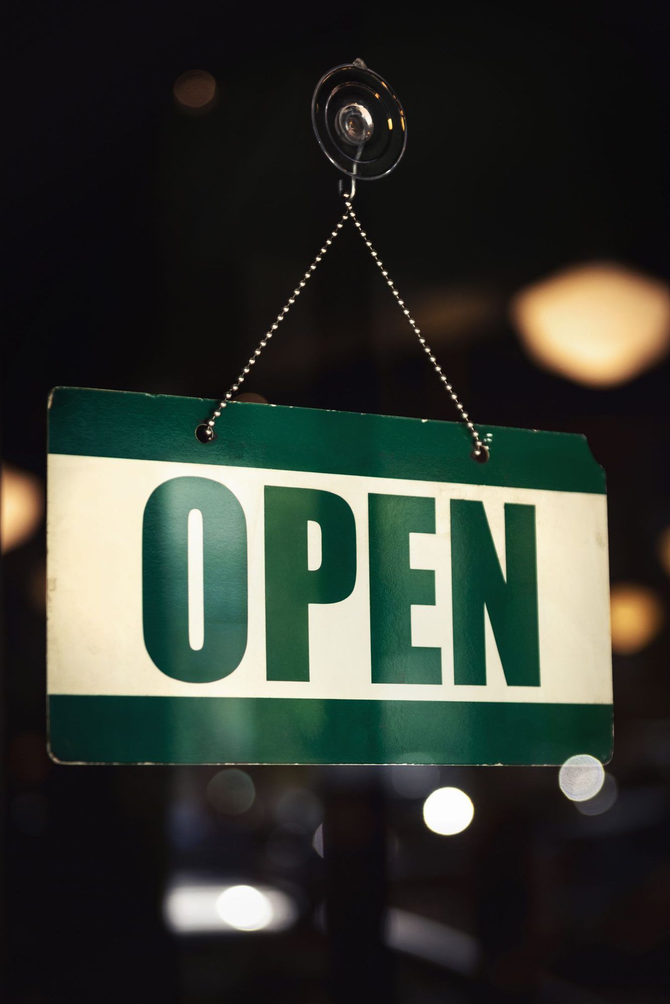 An OPEN sign hanging in a shop door
