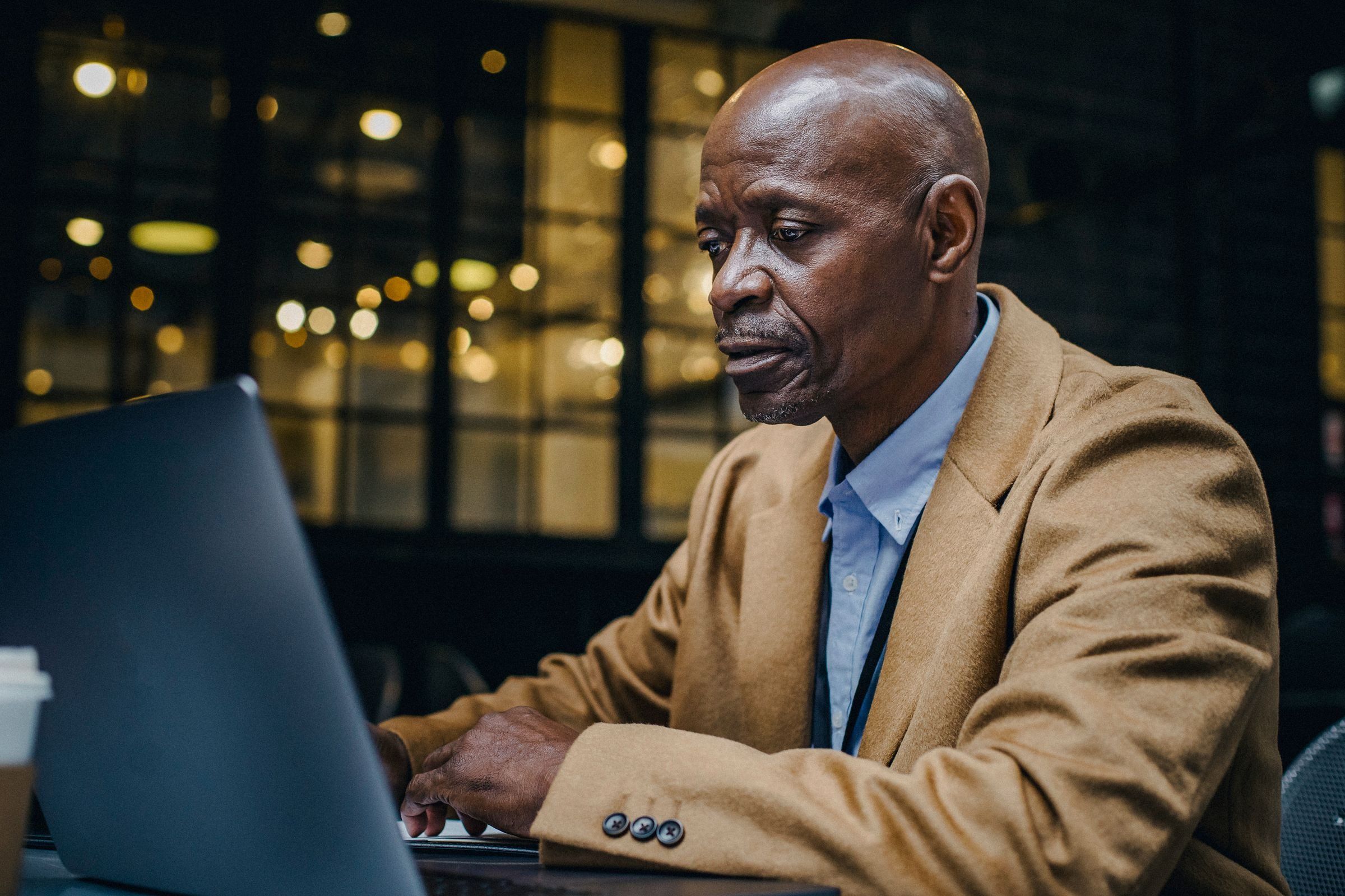A local business owner working on a laptop in a café after hours