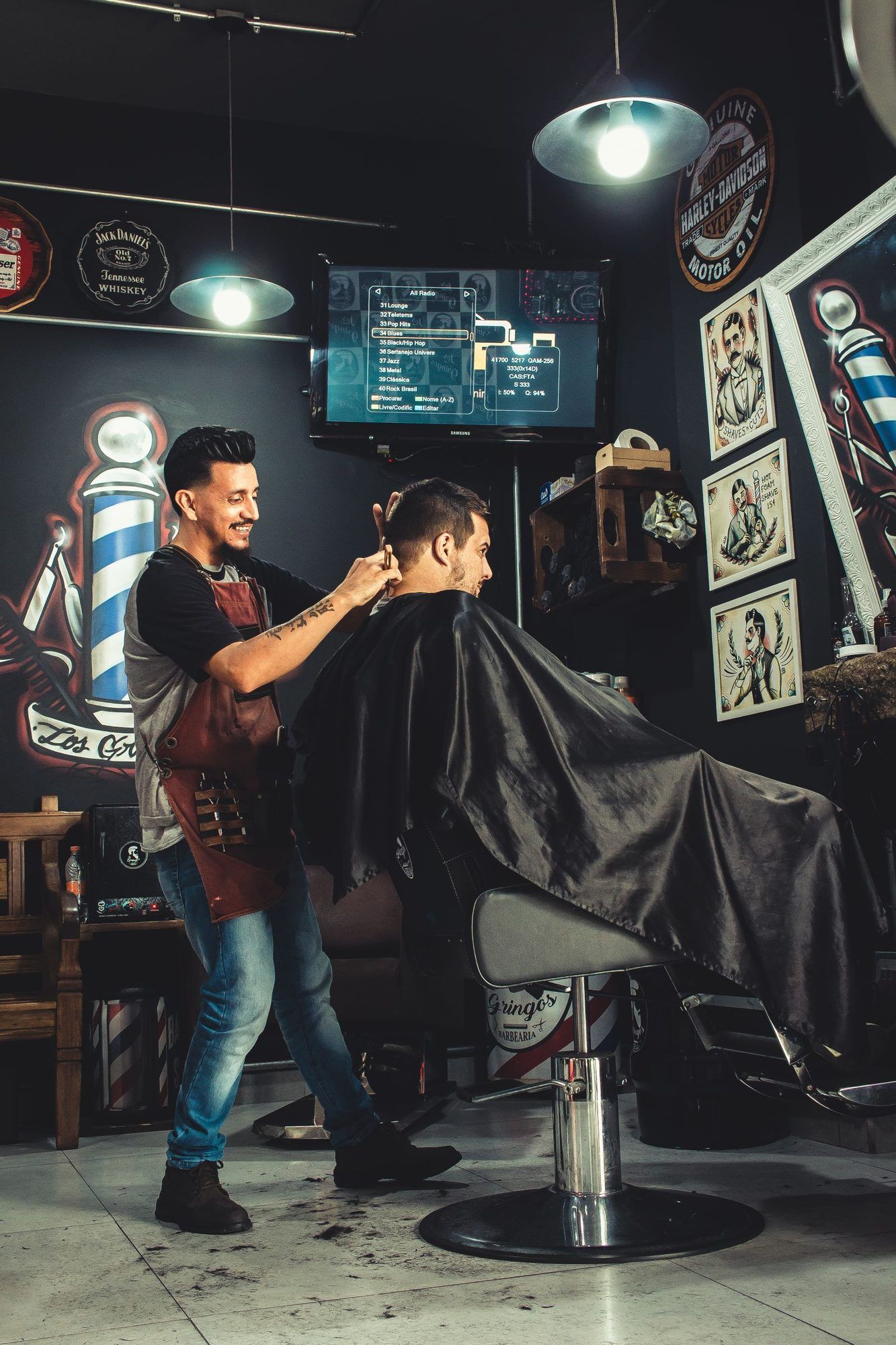 A barber cutting a client’s hair inside a barbershop